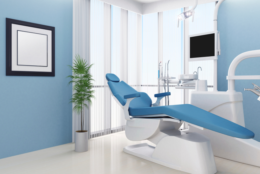 Modern dental operatory with blue chair, equipment, and light blue walls at Breezy Point Smiles clinic.