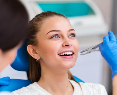 Woman receiving dental examination from dentist in blue gloves at dental office.