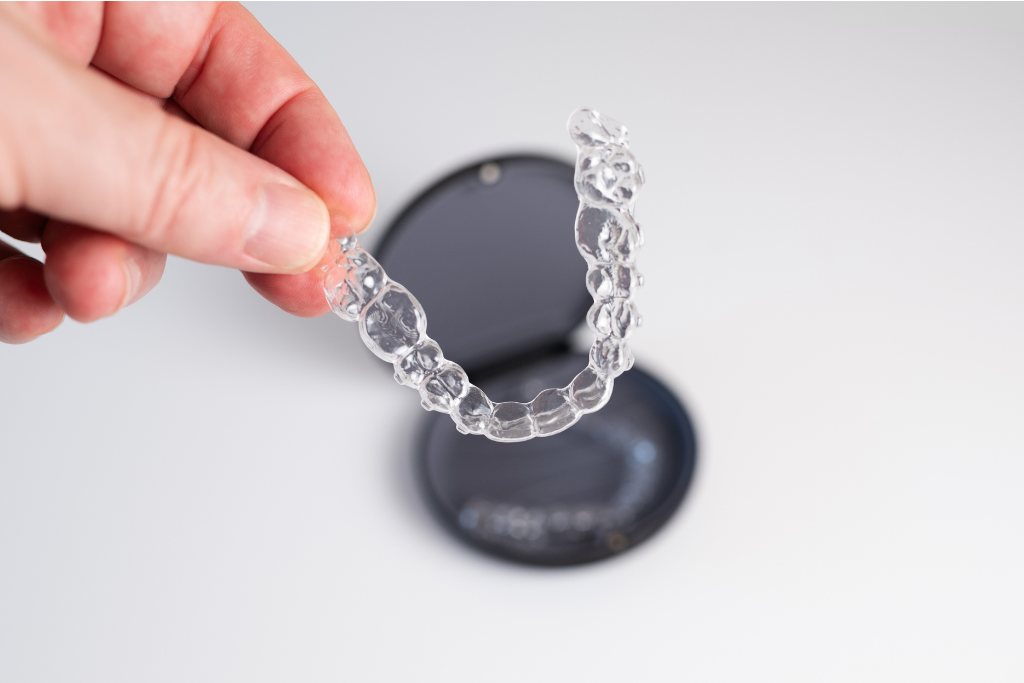Hand holding a clear aligner tray