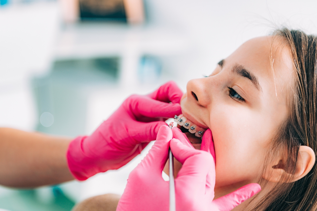 Orthodontist adjusting braces during a child's orthodontic treatment