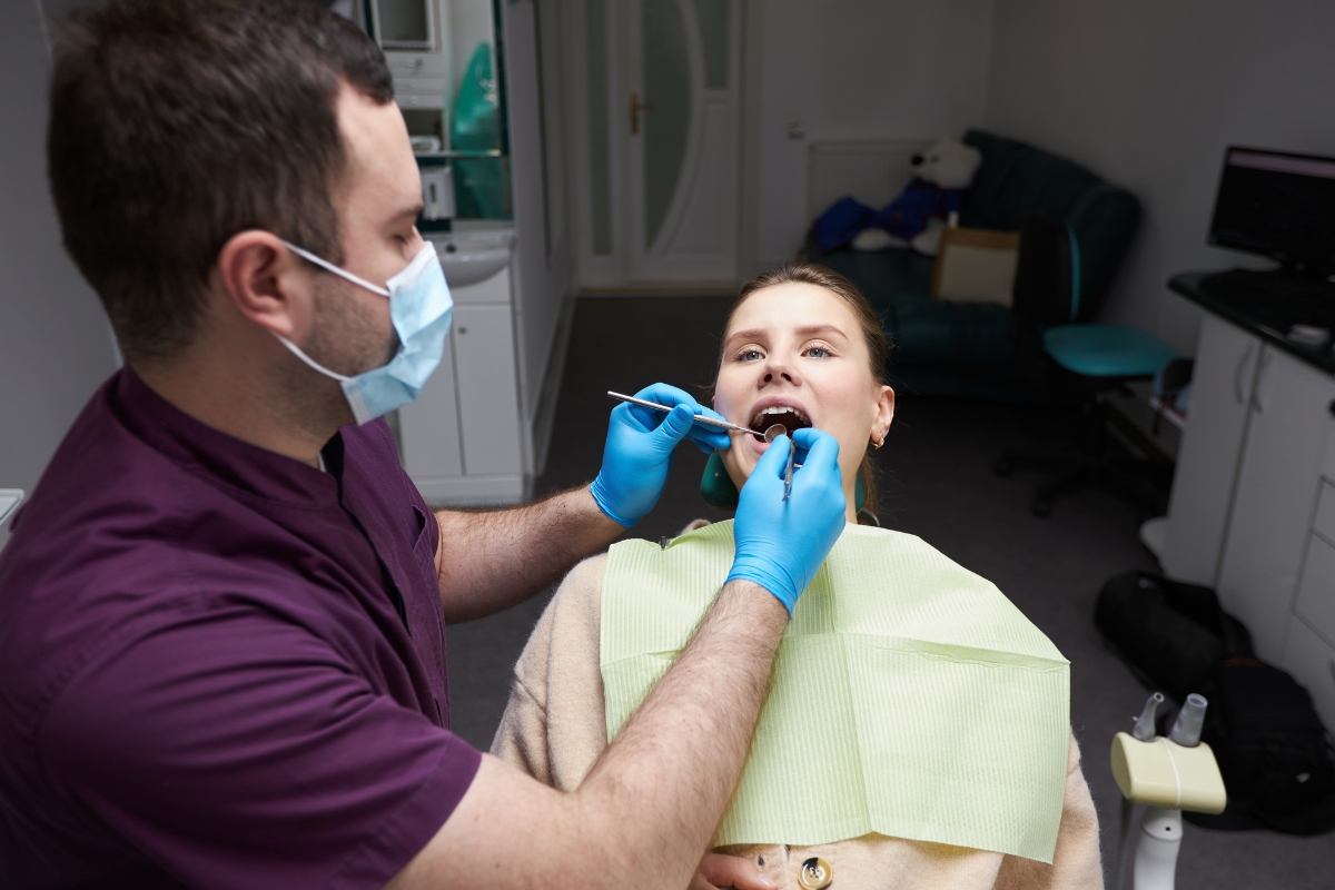 Dentist examines patient’s mouth to detect serious dental problems early
